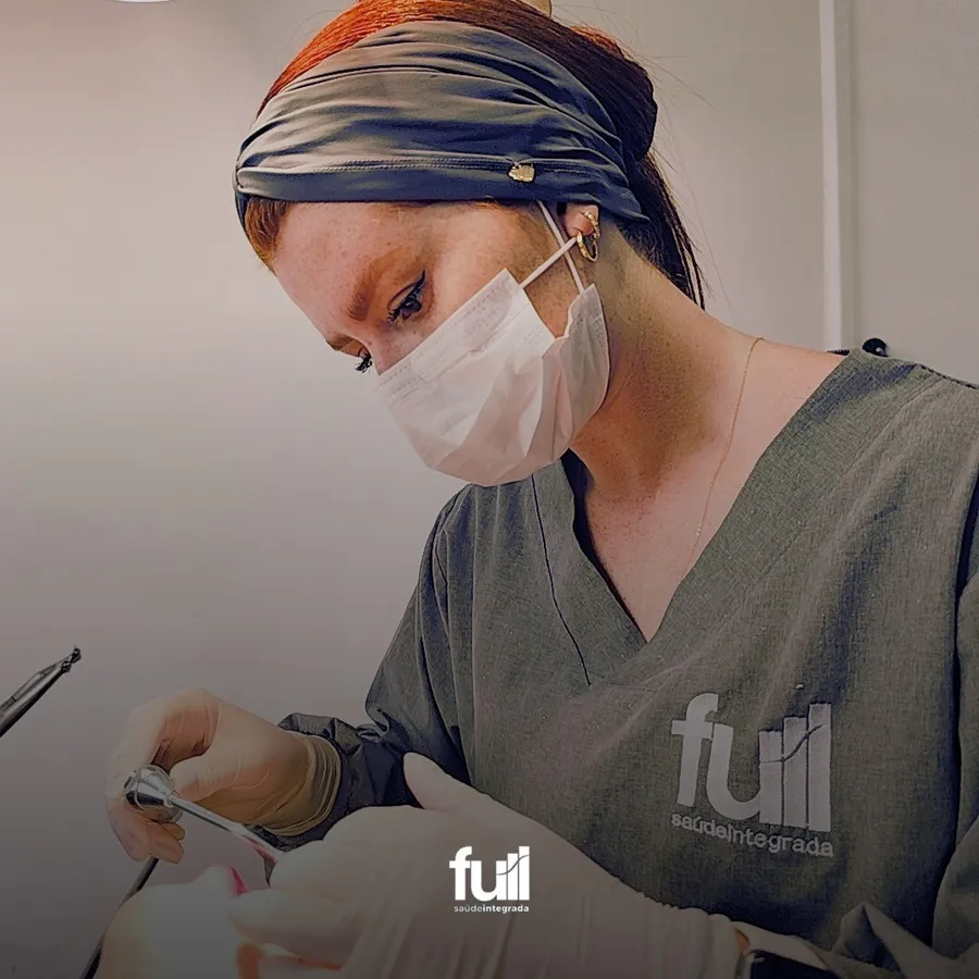 Dentista com máscara e touca durante o atendimento