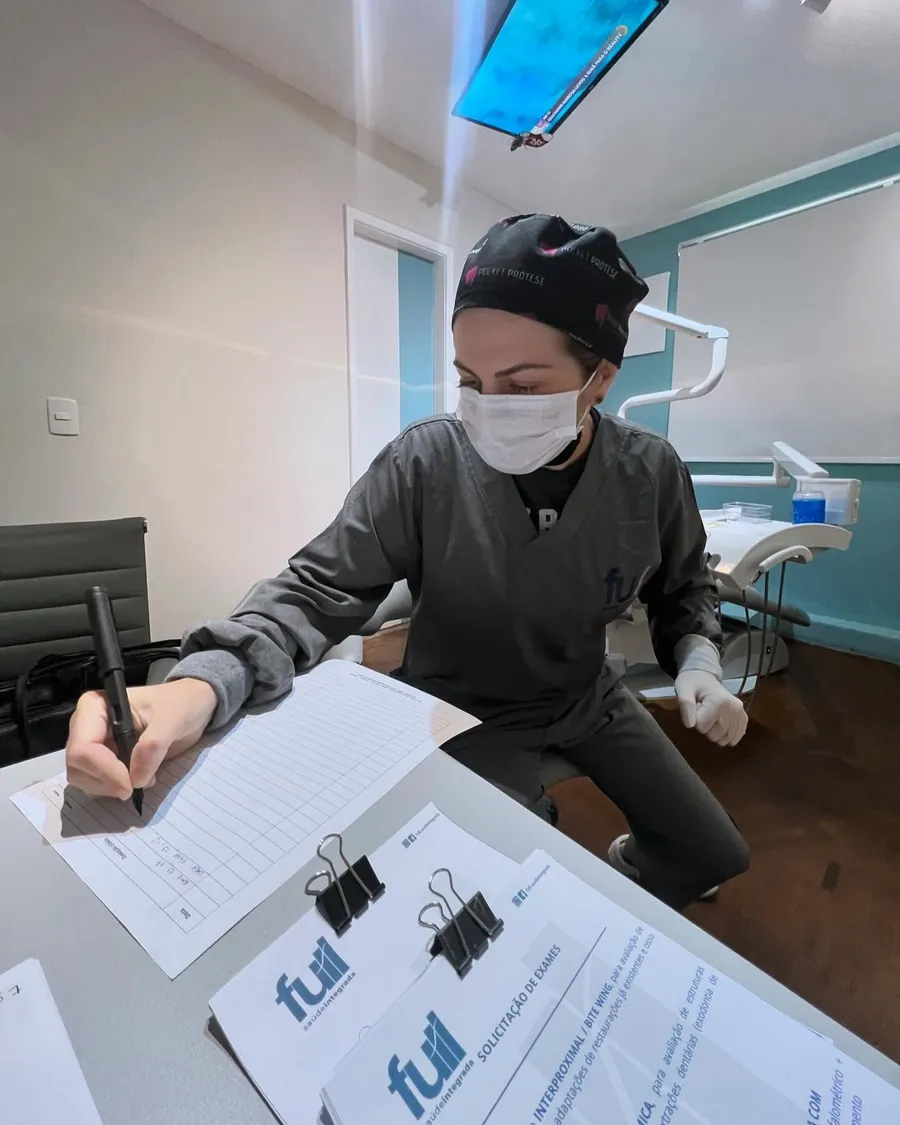 Dentista preenchendo a ficha de planejamento do paciente