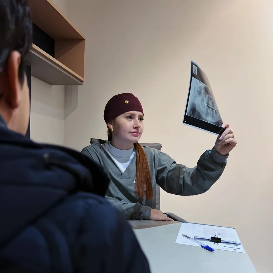 Dentista analisando um raio-x com o paciente